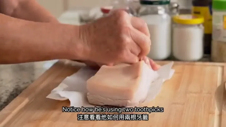 Using two toothpicks held together to poke dense holes across the pork skin