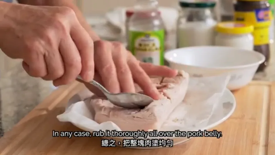 Rubbing the five-spice dry seasoning blend into the scored crevices of the pork belly
