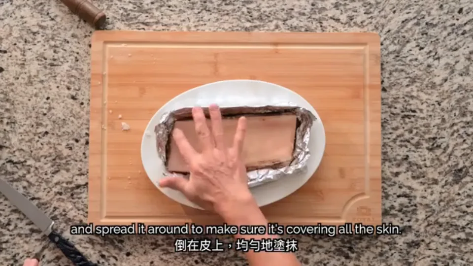 Pouring and rubbing white rice vinegar evenly over the pork belly skin