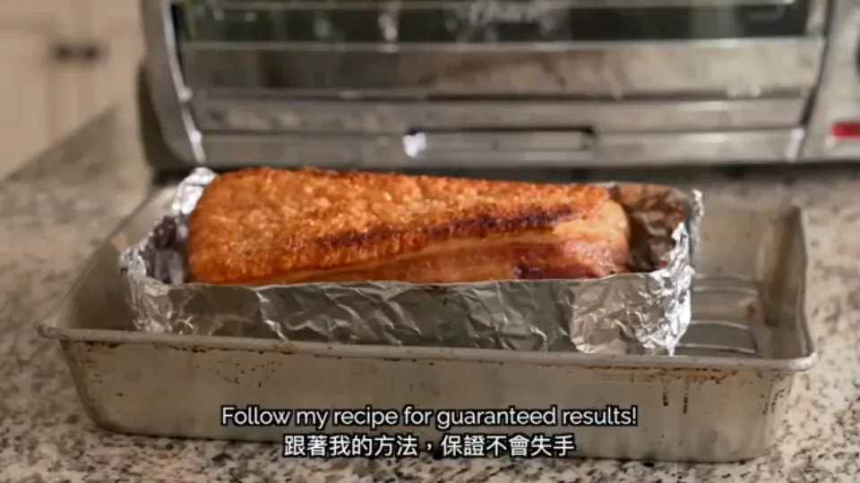 Freshly roasted Cantonese Siu Yuk pulled from the oven with golden blistered crackling