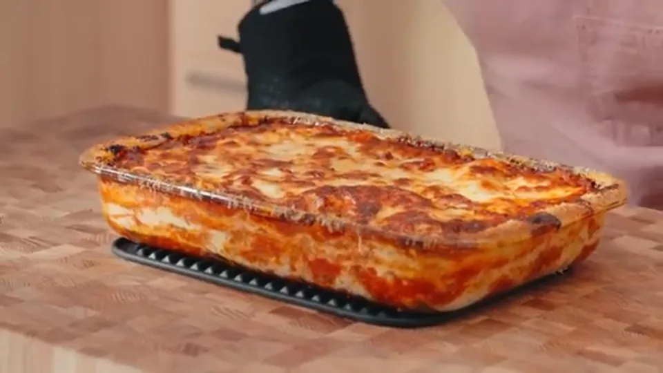Freshly baked golden-brown bubbly classic lasagna resting on board