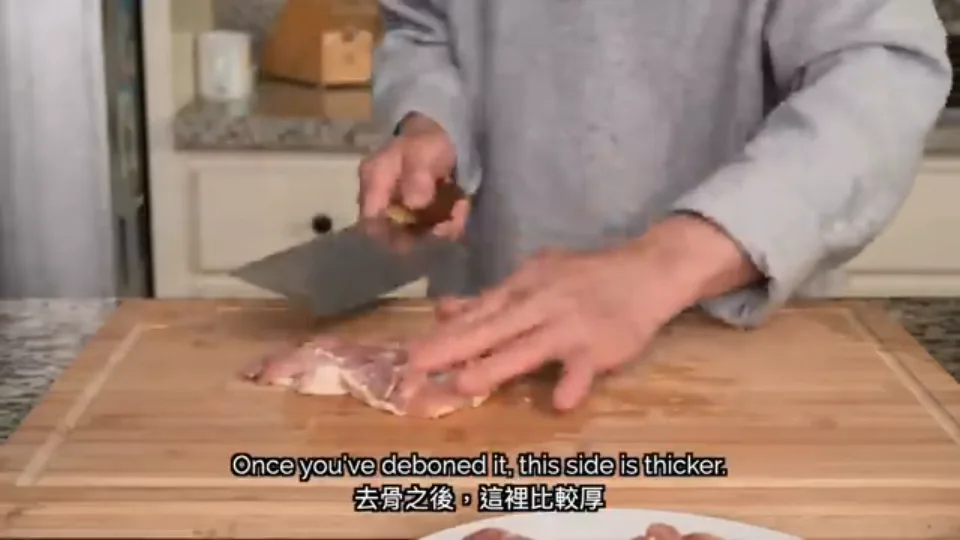 Daddy Lau slicing through the thick section of deboned chicken thigh