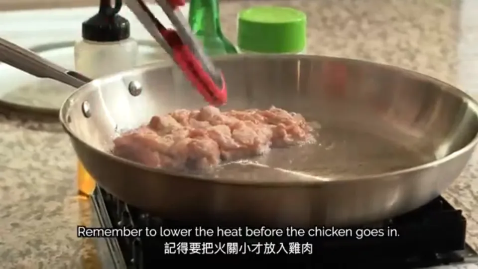 Placing cornstarch-coated chicken thighs skin-side down in the hot skillet