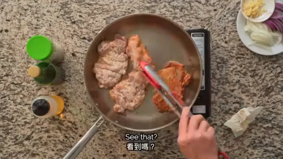 Flipping the golden crispy chicken thighs with cooking tongs