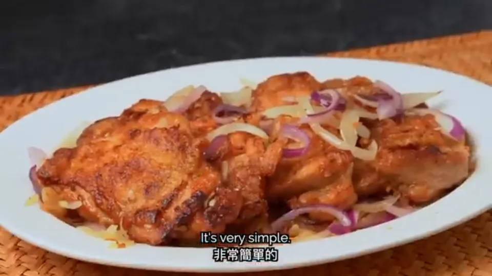 The finished plate of crispy pan-fried chicken thighs garnished with onions